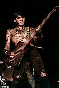 a man with tattoos on his body playing a guitar