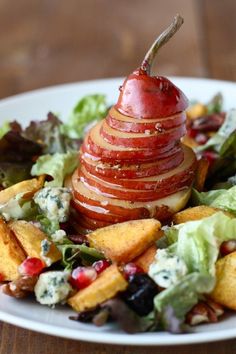 an apple is stacked on top of a salad