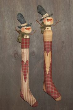 two wooden snowmen with hats and scarfs