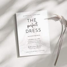 a paper with the words the perfect dress written on it next to a dried flower