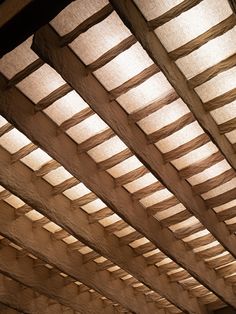 the inside of a wooden structure with light coming in from it's windows and ceiling