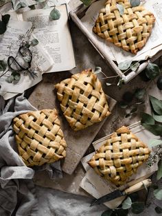 three pies sitting on top of a table covered in leaves