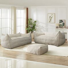 a living room filled with furniture and a white rug on top of a hard wood floor