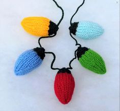 four knitted christmas lights are hanging on a string in the shape of acorns