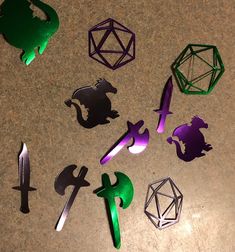 paper cut out of different shapes and sizes on a table with scissors, dices, and other items