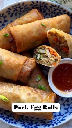 pork egg rolls on a blue and white plate with dipping sauce