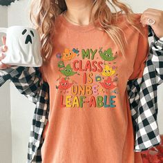 Searching for the perfect Fall Preschool Teacher Shirt Comfort Colors, Cute Autumn Teacher Shirt, Funny Leaf TShirt for Fall, or Teacher Graphic Tee for School T-Shirt; then look no further! -PRODUCT DESCRIPTION- Get into the fall spirit with this adorable "My Class is Unbe-leaf-able" shirt, perfect for teachers who love to bring a little seasonal fun to their classroom! Featuring cute and colorful leaf characters, this graphic tee is ideal for showing off your love for teaching during autumn. Crafted with Comfort Colors garment-dyed fabric, this shirt offers unbeatable coziness and durability, thanks to its 100% ring-spun cotton material. The relaxed fit and crew neckline make it easy to pair with jeans or leggings for a casual and comfortable school day look. Designed with double-needle Preschool Teacher Shirts, Fall Preschool, Cute Autumn, Preschool Teacher, Dyed Fabric, Teacher Shirts, Comfort Colors, Crew Neckline, Cotton Material