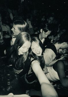 a group of young women sitting next to each other at a music concert in black and white