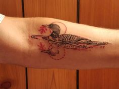 a bird on the arm with red leaves around it