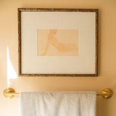 a white towel hanging on the wall next to a gold faucet