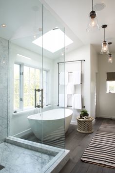 a bathroom with a large tub and glass walls