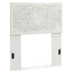 a white fireplace surround with intricate carvings on the top and bottom part, in front of a white background