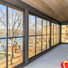 an empty room with large windows and a view of the water from it's floor