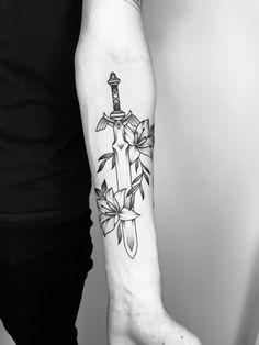 a person with a tattoo on their arm holding a knife and flower arrangement in the other hand