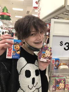 a woman holding up two cell phones in front of her face and smiling at the camera