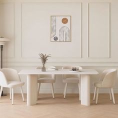 a white dining table and chairs in a room with wood flooring on the walls