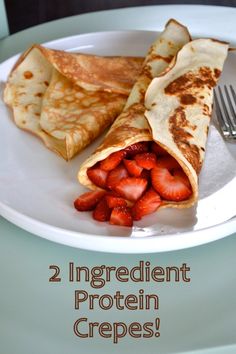 a white plate topped with crepes and strawberries