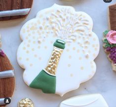 decorated cookies are arranged on a table with wine bottles and other items in the background