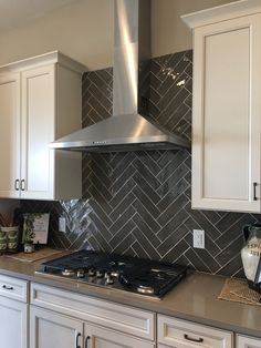 a stove top oven sitting inside of a kitchen next to white cabinets and cupboards