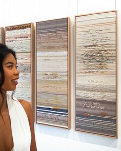 a woman standing in front of two wall hangings