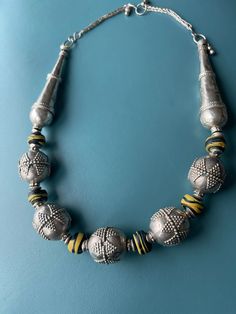 Yemen Ethnic vintage Bridal,silver beads necklace with African Black glass with Yellow Twirl, new life necklace. This necklace is a combination of Yemen vintage silver beads and West African Glass beads. the two very long cone beads are old/antique in good silver. The silver beads are vintage the decoration is new pattern compared to the more traditional Birdal beads. Second life given to old beads. Unique Silver Necklace With Dangling Beads, Silver Amulet Style Beaded Necklace, Silver Beaded Amulet Necklace, Unique Silver Beaded Necklaces With Polished Beads, Unique Silver Necklace With Polished Beads, Spiritual Silver Necklaces With Dangling Beads, Spiritual Silver Necklace With Dangling Beads, Traditional Silver Necklaces With Spacer Beads, Silver Large Beads Amulet Style