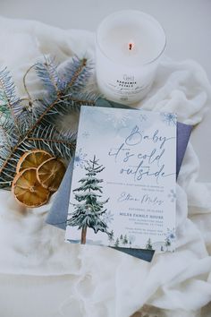 the bridal shower is next to a candle and some pine cones on a blanket