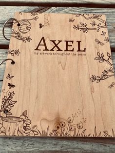 a wooden notebook with the words axel written on it and an image of flowers