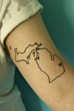 a woman with a tattoo on her arm that has a map of the state of michigan