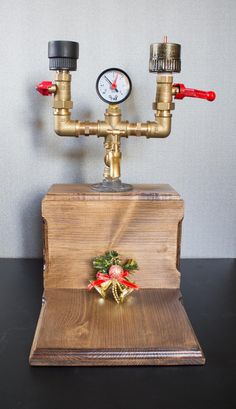 a wooden box with two valves and a clock on the top that is attached to it