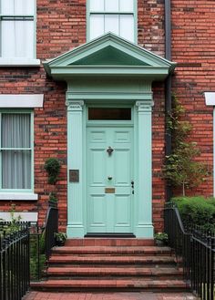 a green door on the side of a brick building