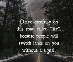 a road with trees and mountains in the background that says drive carefully on this road called life because people will switch lanes on you without a signal