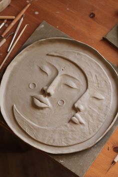 a clay face sitting on top of a wooden table