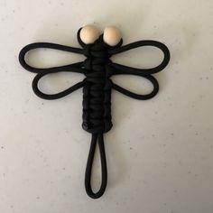 a black dragonfly brooch with two white balls on it's back end