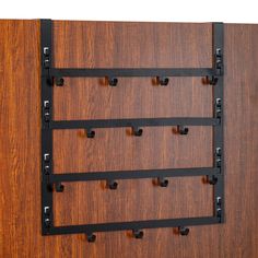 a wall mounted coat rack with five hooks and four bars on the bottom half of it