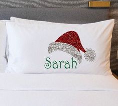 a white bed topped with pillows and a santa hat