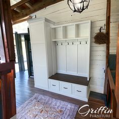 a room with some white cabinets and drawers on the wall next to a purple rug