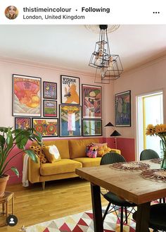 a living room filled with furniture and pictures on the wall next to a wooden table