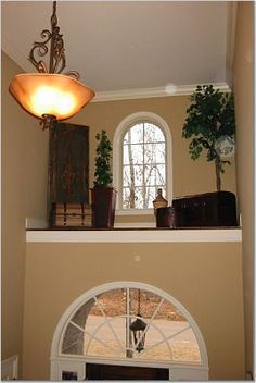 the light fixture is on above the fireplace in the living room, which also has an arched window