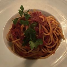 a pasta dish with tomato sauce and parsley garnished with parsley on top