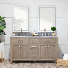 a bathroom vanity with two mirrors above it and a potted plant in the corner