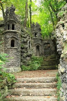 an old stone castle with stairs leading up to the door and windows on each side