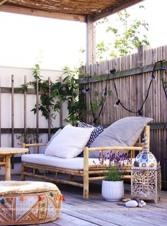 an outdoor patio with furniture and plants on the deck, including a hammock