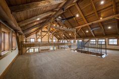 an empty room with wooden beams and ceiling fans