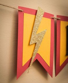 a yellow and red banner with a lightning bolt on it hanging from a line next to a wall