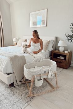 a woman sitting on top of a bed holding a dog