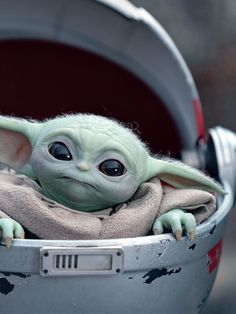 a baby yoda doll sitting in a trash can