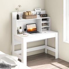 a white desk with a laptop on top of it next to a window in a room