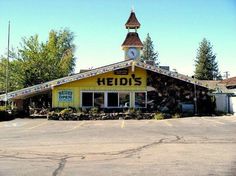 a yellow building with a clock tower on the top and letters that read hedi's