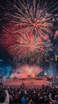 Colorful fireworks bursting in the night sky above a crowded city skyline.