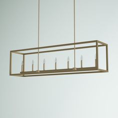 a large rectangular light fixture with five candles hanging from it's center and four lights on each end